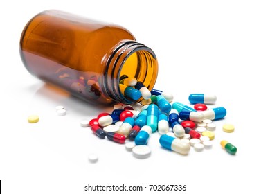 Pills Spilling Out Of Pill Bottle On White Background