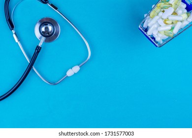 Pills And Stethoscope On Medical Desk Flat Lay Blue.