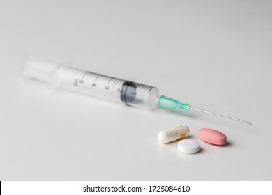 
pills with a syringe on a white background