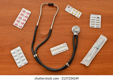 Pills, Tablets, Stethoscope, Syringe Medical Supplies Isolated On Wooden Background, Top View, Top Shot, Virus Protection Concept.