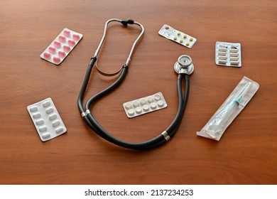 Pills, Tablets, Stethoscope, Syringe Medical Supplies Isolated On Wooden Background, Top View, Top Shot, Virus Protection Concept.