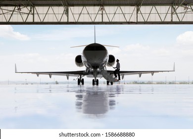 Pilot Boarding Private Jet In Hangar