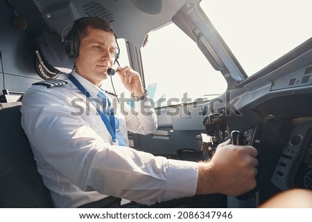 Pilot bringing microphone of headset to his mouth