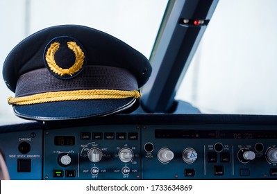 Pilot cap hanging on airplane dashboard, cockpit