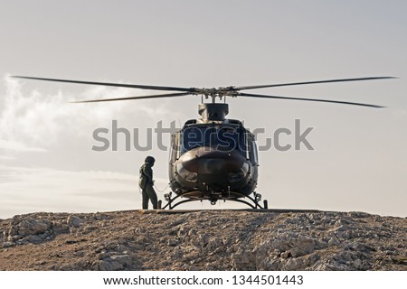 Pilot checking military helicopter before taking off from helipad on top of mountain. Military, airforce, defense and mountain rescue concepts. Zdjęcia stock © 