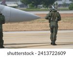 A pilot and co pilot in a G-suit inspects a fighter jet. Control panel area on the side of the aircraft fuselage. Check readiness before flying.