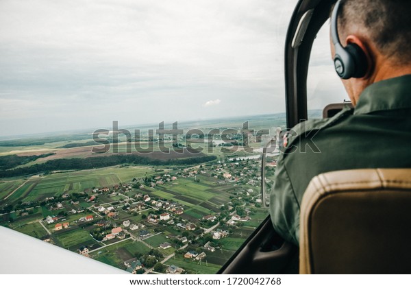 Pilot and cockpit.\
Aircraft Pilot at work. Rear view of pilots. A beautiful view from\
the cockpit of a helicopter. Professional helicopter pilot,\
military might. 