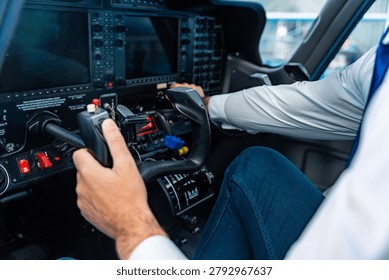 Pilot demonstrating expertise and control while operating flight controls in a modern private airplane cockpit, navigating complex instrument panels and screens in preparation for flight