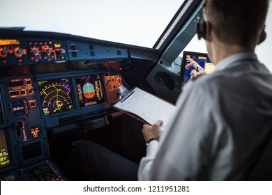 Pilot Executing Pre-flight Procedures In A Commercial Airliner Cockpit Before Takeoff