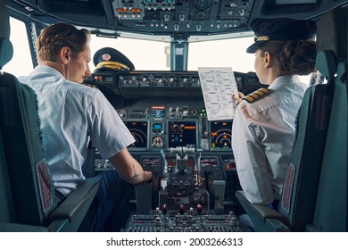 Pilot and female first officer seated in the flight deck