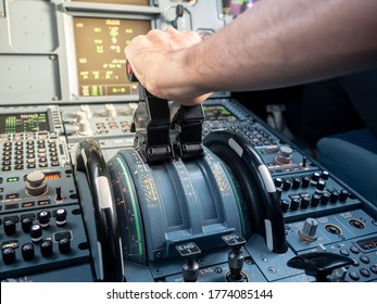 Pilot Hand On Thrust Lever In A320 Aircraft. Warm Sunlight In Cockpit. Concept Of Power.