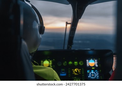 Pilot of helicopter emergency medical service flying over landscape at dusk. Themes emergency medicine, rescue, and emergency help.
 - Powered by Shutterstock