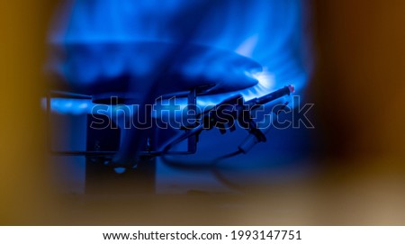 Pilot light auto igniter inside a hot water heater with flames