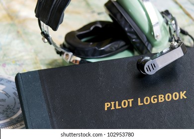 Pilot Logbook And Headset On A Map