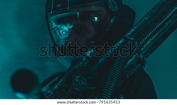 Pilot, man of\
the future or space with futuristic helmet and fantasy lights,\
carries a laser weapon in his\
hands