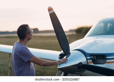 Pilot man standing next to a small private airplane - Powered by Shutterstock