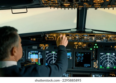 The pilot presses the power buttons on the control panel to control the aircraft in front of cockpit windshield - Powered by Shutterstock