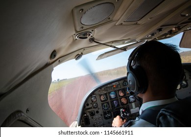 Pilot In A Small Airplane Cockpit Landing On A Rural Dirt Airstrip