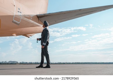 Pilot in uniform checks the aircraft before the flight in airport - Powered by Shutterstock