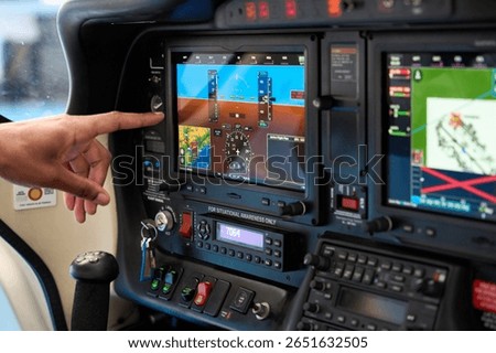 Pilot using touch screen in airplane cockpit during flight training