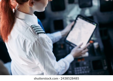 the pilot woman holds a tablet in his hands, looks at the flight route - Powered by Shutterstock