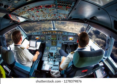 Pilots fly the plane. View from the cockpit of a modern passenger plane on the clouds behind the aircraft window.