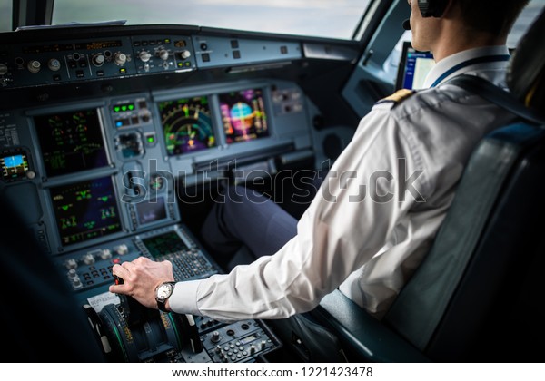 Pilot\'s hand\
accelerating on the throttle in  a commercial airliner airplane\
flight cockpit during\
takeoff