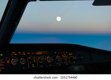 Pilots View Out Of The Cockpit Window Toward Sunset Sky With The Moon Rising High