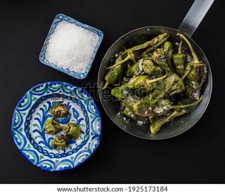 Pimientos de padron. Grilled green peppers with salt on the side. Spanish cuisine. Flat lay. Roasted