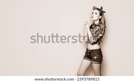 Pin up girl. Portrait of attractive woman showing hand sign gesture. Retro and vintage concept. Pinup female model pose at studio. Brown toned black and white bw photo