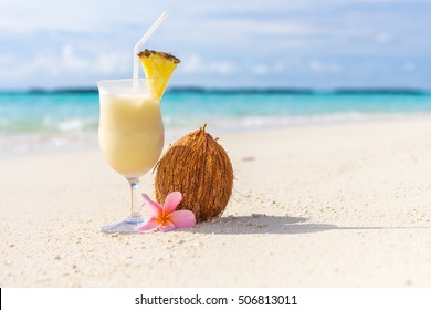 Pina Colada Cocktail On The Beach With Coconut And Exotic Flower