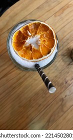 A Pina Colada With Paper Straw And Orange Garlish, Shot From Above.