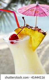 Pina colada tropical drink at sandy beach on the ocean