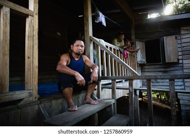 Pinangah, Sabah / Malaysia - March 09 2018: A Portrait Of Man Sitting On The Stair Of His Wooden House At Kampung Kenang-Kenangan.