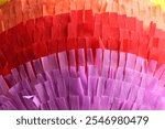 Pinata. Cut tissue paper in different colors as background, closeup