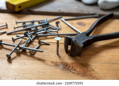 Pincers And Nail Stack On Wood. Carpenter Work Bench Table, Closeup View, Joinery Workshop
