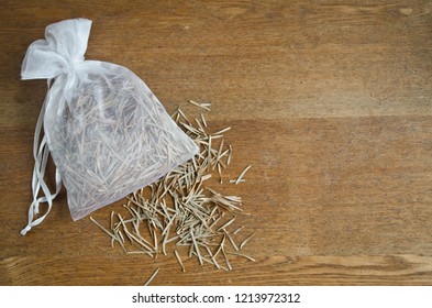 Pine needle sachet in white drawstring bag of scented herbs with space for copy for banner or website header for health, wellness, botanical, nature.