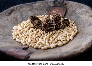 Pine nuts and pine cones in wood bowl. Pinenuts concept