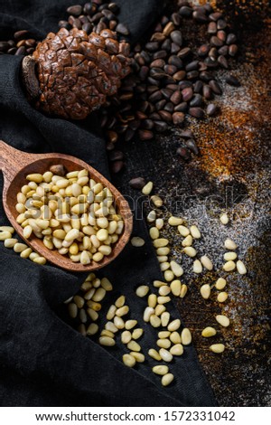 Pine nuts on stone table. Black background. Top view