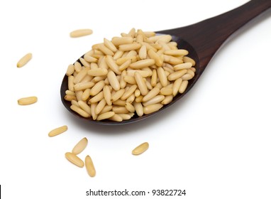 pine nuts in a wooden spoon isolated on white background