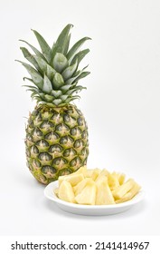 A Pineappla Nd A Bowl Of Pineapple Chunks On A White Background