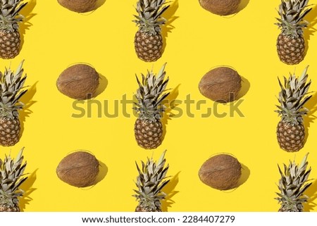 Pineapple and coconut on a yellow background. Minimal and modern design. Pattern.