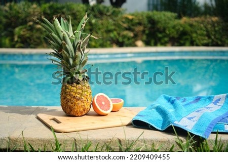 pineapple and grapefruit on the edge of the pool