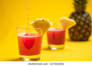 Pineapple Juice In Glass Closeup Near Sliced Fruit With Spash And Dripping Liqid For Summer Vibes. Healthy Organic Beverage On An Orange Background, Copyspace.