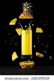 pineapple juice in a glass on a black background with reflection with splashes and splashes. High quality photo