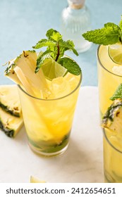 Pineapple mojito with muddled mint and lime served with a sugar cane stick