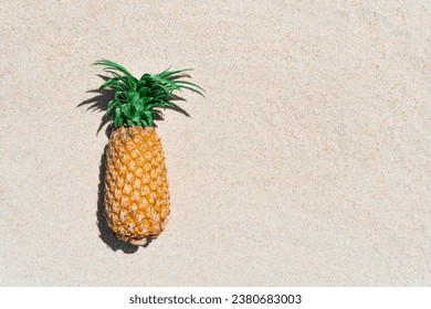 Pineapple on sand beach on a clear summer day, Summer time concept.