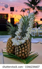 Pineapple On Table At Luau And Hawaiian Lei At Sunset Hawaii