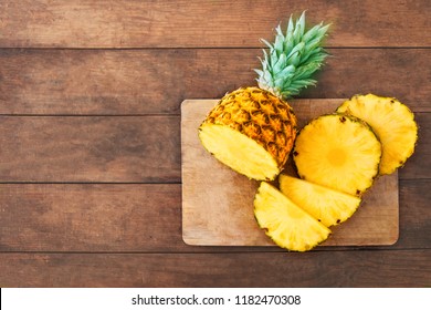 Pineapple on wood texture background. Whole and sliced tropical pineapple on wooden cutting board  with copy space. Top view
 - Powered by Shutterstock