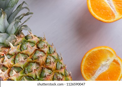 Pineapple and oranges on white background, citrus top view, cut oranges for fruit salad, vegetarian food, tropical fruits for diet, copy space